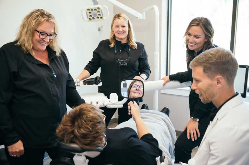 Dental patient seeing their new smile in the mirror