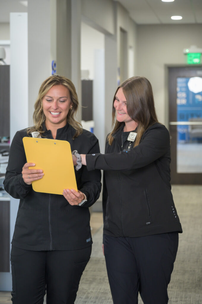 Two women working at a dental office looking at paperwork