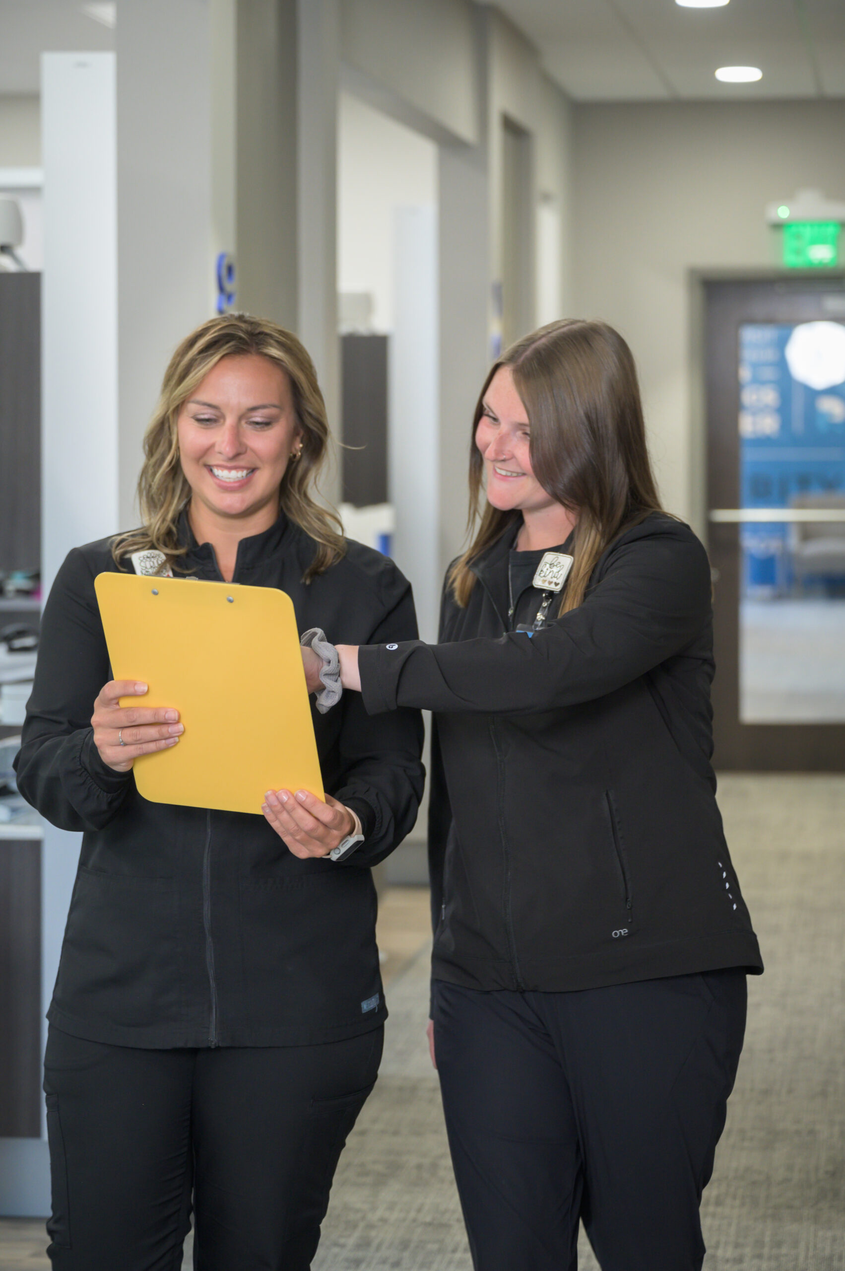 Two women working at a dental office looking at paperwork